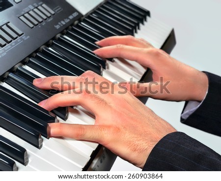 Hands of musician playing on a synthesizer, isolated on a white