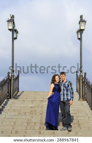 Beautiful couple in love standing on stone stairs with lanterns