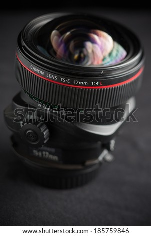 Moscow, Russia - April 05, 2014: 17mm Wide Ange Tilt-shift Canon EF Mount Lens isolated on a black blackground. This lens is one of the most complicated and expensive in the Canon line-up.