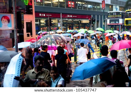 HONG KONG - MAY 20: People in the rain on May 20, 2012 in Hong Kong. With a land mass of 1,104 km and population of 7 million people, Hong Kong is one of the most densely populated areas in the world