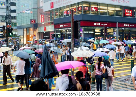 HONG KONG - MAY 20: People in the rain on May 20, 2012 in Hong Kong. With a land mass of 1,104 km and population of 7 million people, Hong Kong is one of the most densely populated areas in the world