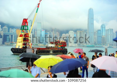 HONG KONG - MAY 19: People in the rain on May 19, 2012 in Hong Kong. With a land mass of 1,104 km and population of 7 million people, Hong Kong is one of the most densely populated areas in the world