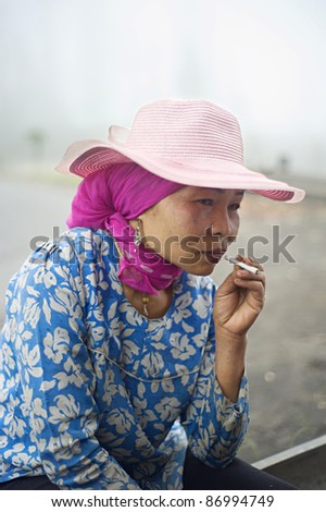 PROBOLINGO, INDONESIA - APRIL 24: Unidentified Indonesian woman smoking  cigarette on April 24, 2011 in Probolingo, Indonesia. Over 165 million people smoke in Indonesia.