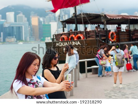 HONG KONG - MAY 18, 2013: Pretty young female tourist makes selfie in Hong Kong. According to the Hong Kong Tourism Board ,overall visitor arrivals to Hong Kong in 2013 totalled over 36 million