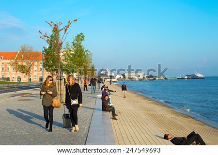 LISBON, PORTUGAL - DECEMBER 24, 2014: People walking on the embankment of Lisbon - famous tourist attraction.
