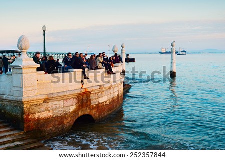 LISBON, PORTUGAL - JAN 10, 2015: People watching sunset at Tagus river embankment in Lisbon. Tourism is contributing about 5% of the Gross Domestic Product