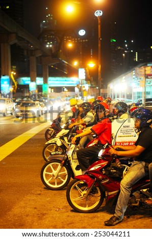 KUALA LUMPUR, MALAYSIA - MARCH 16, 2012: Motorcyclist on the road in Kuala Lumpur. The road network system in Kuala Lumpur is similar to the city road network system in major Chinese cites