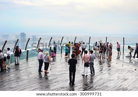 SINGAPORE - MAY 04, 2015: People at view point on top of Marina Bay Sands Hotel. It is billed as the world\'s most expensive standalone casino property at S$8 billion