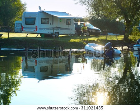 Camping site on a lake with caravans and boats