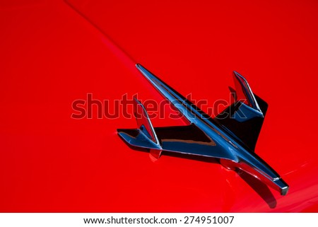 BURBANK, CA - MAY 1, 2015: Close up of a 1955 Chevrolet Bel Air chrome hood ornament on a red hood. 1955 was the first year the Bel Air was available with a V8 as an option.