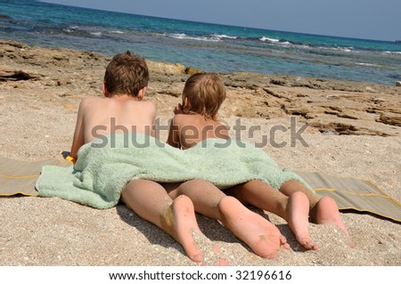 The boys lie on the beach and dream of distant travels