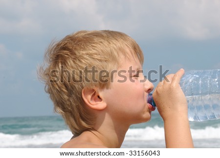 Boy drinking water from a bottle on a hot day