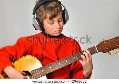 boy at a rehearsal with headphones, playing guitar