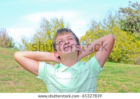 Autumn in the park, the boy raised his head to the sky and watching the autumn sun
