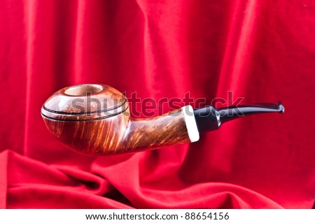 A new pipe for tobacco smoking was photographed against a red background