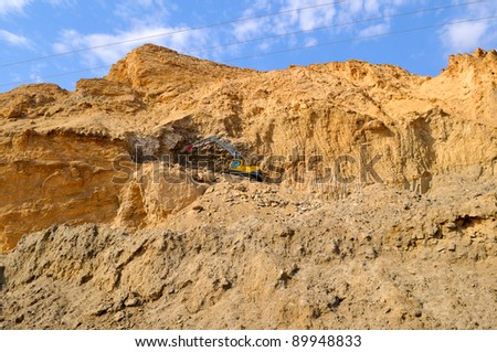 excavator working in the mountains overlooking the Dead Sea is paving a new road