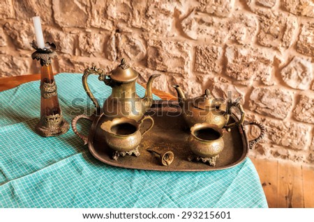 Dinner set of dishes for coffee and tea from the old bronze bell on the tray with the call for workers