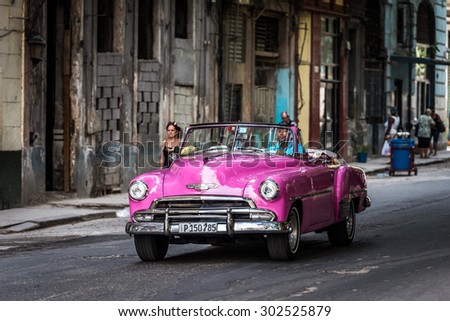 HAVANA, CUBA - JULY 05, 2015: HDR pink american classic car drive on the street at the Malecon promenade.