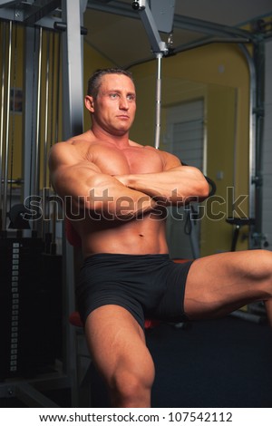 Bodybuilder sits in his training room