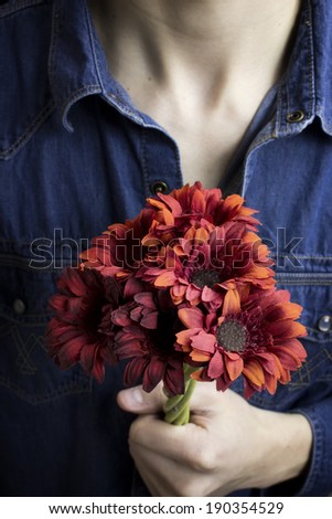 Close up red flowers being held by man
