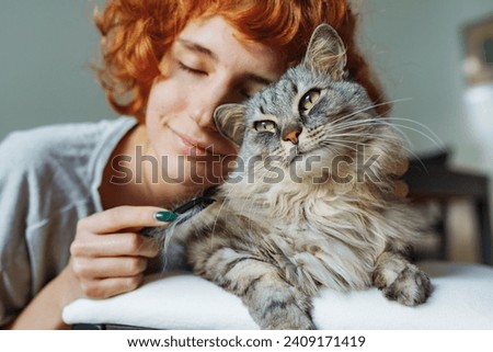 Similar – Image, Stock Photo Striped fluffy cat with green eyes basking in sun