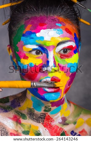 Emotions of asian woman with face art and color brush
