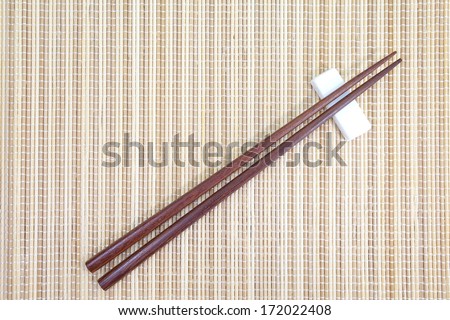 brown wood chopsticks and traditional bamboo plate mat