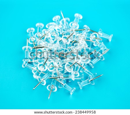 Pile of thumb tacks with colorful background