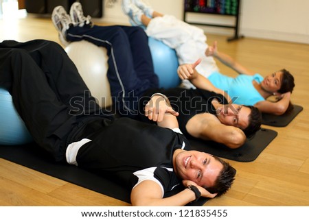 Group of two men and one woman exercising on gymnastics balls