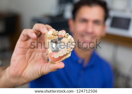 Dental technician presenting dental prosthesis in a dental lab