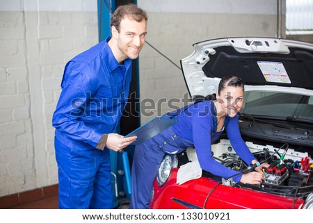 Car mechanics repairing car electrics and other parts of the motor