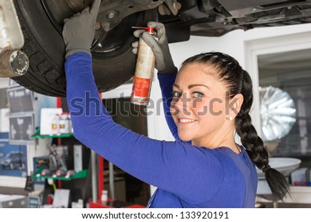 Car mechanics repairing a car on hydraulic lift