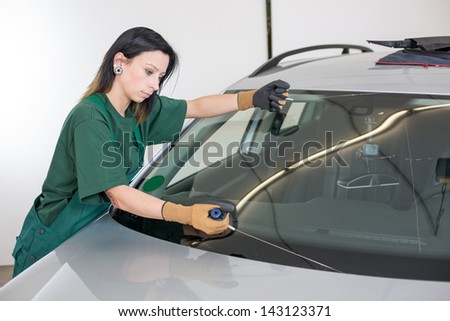 Glazier cutting adhesive of windscreen with a wire to replace windshield