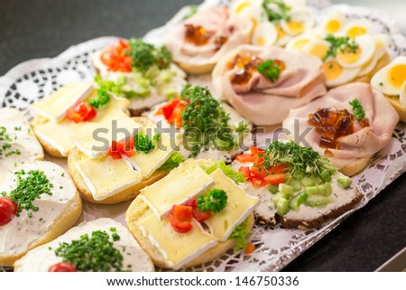 Sandwiches on tablet at a buffet with cold meat, eggs and cheese