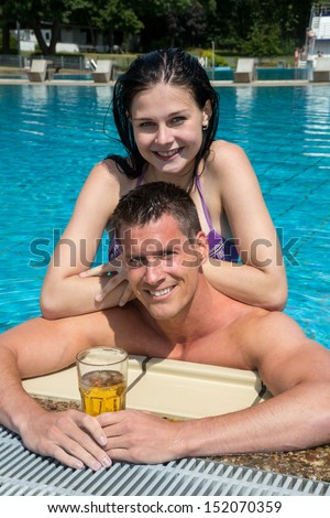 Couple enjoying drinks in their holidays at swimming pool