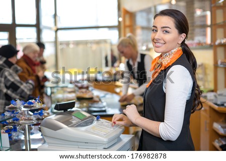 Shopkeeper and saleswoman at cash register or checkout counter