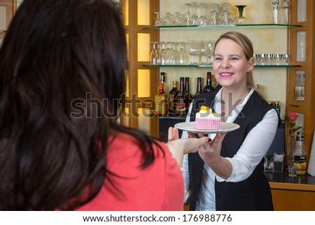 waitress hands a piece of cake to customer