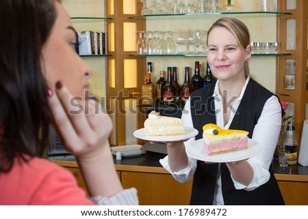 Shopkeeper in confectionary gives client a piece of cake and coffee