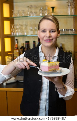 Waitress presenting a piece of cake in cafe