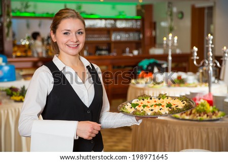 Catering service employee or waitress posing with a tray of appetizers