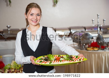 Catering service employee or waitress posing with tray for buffet