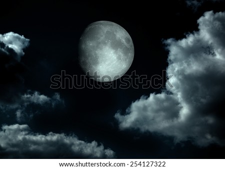 The moon in the night sky in clouds \