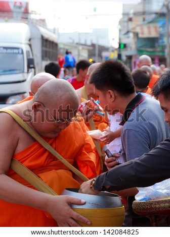 PHRAE, THAILAND - OCT 31 : Unidentified Buddhist monks are given food offering from people in the morning for End of Buddhist Lent Day. on October 31, 2011 in Muang, Phrae, Thailand.