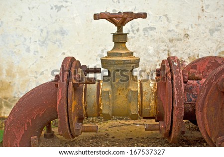 Old rusty industrial tap water pipe and valve