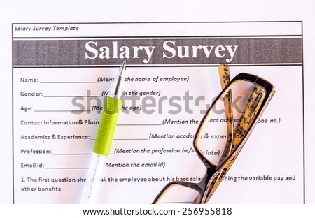 Glasses and pen on salary survey from on the table