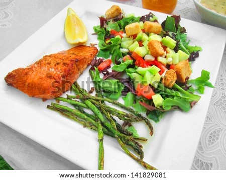 Healthy meal dinner lunch on white plate with fish salmon trout and greens veggies