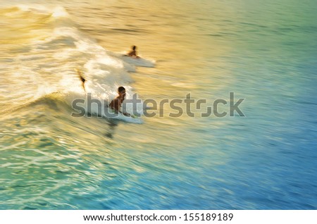 Two boys surfing on a body boards