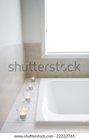 A row of tealight candles on the edge of a bathtub