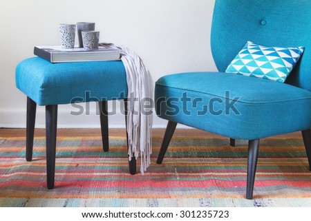 Teal retro armchair and colorful pink pattern rug interior with ottoman horizontal
