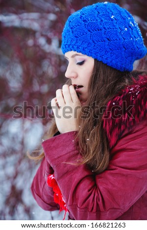 Winter woman in snow outside on snowing cold winter day. Portrait Caucasian female model outside in first snow